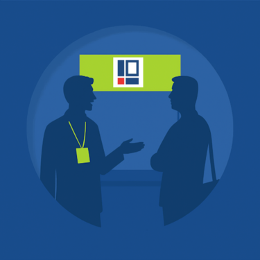 Two stylized people are standing in front of a Projektron trade show booth and talking.