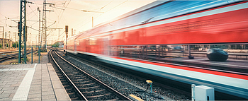 Red high-speed train in motion at the station