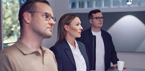 Three people at Kemény Boehme Consultants SE in conversation – teamwork and exchange in a professional atmosphere.