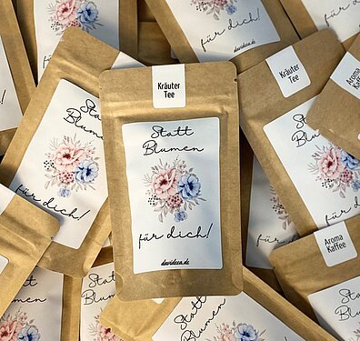 Geschenktüten mit Tee- und Kaffeevariationen und der Aufschrift „Statt Blumen für dich“ zum Frauentag 2026 bei der Projektron GmbH.